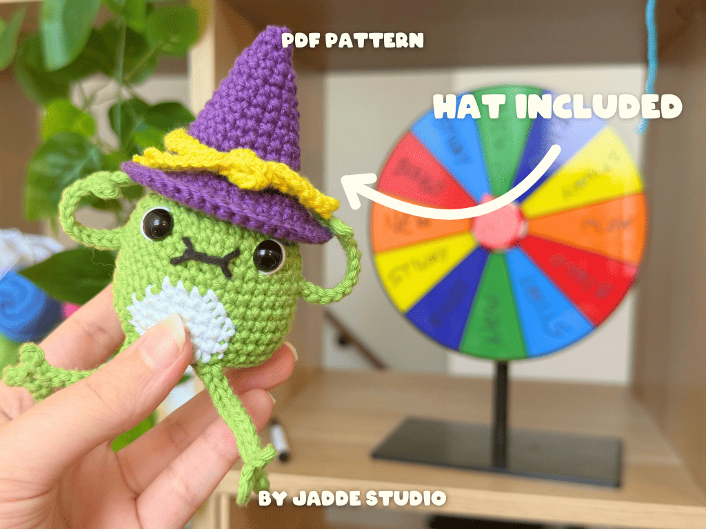 A hand holds a small purple crocheted donut-shaped item with text overlays reading 'THE INSIDE IS CLEAN' and 'BY JADDE STUDIO' against a blurred colorful background.
