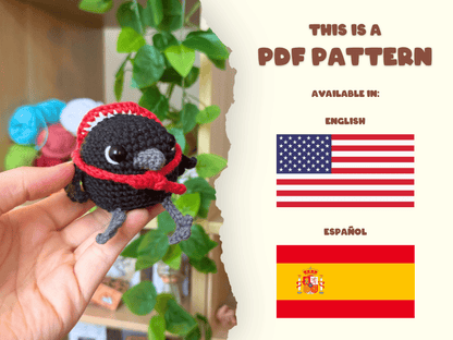 A hand holds a small crocheted bird plush wearing a red headband and red scarf. The right side of the image is a cream-colored panel with text reading 'THIS IS A PDF PATTERN' and flags for English and Español, indicating the pattern is available in those languages.