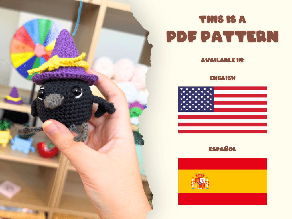 A hand holds a small crocheted black bird wearing a purple witch hat with yellow trim, set against a blurred craft room background. On the right, a cream-colored torn-paper style panel reads 'THIS IS A PDF PATTERN' and lists available languages with US and Spanish flags.