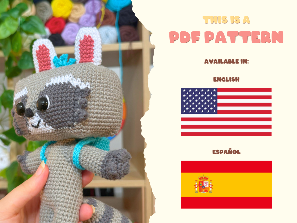 A crocheted raccoon plush toy is held in a person's hand against a blurred craft room background, with a torn-paper style divider and text on the right reading 'THIS IS A PDF PATTERN' plus flags for English and Español. A small copyright line for Jaddie Crochet appears at the bottom.