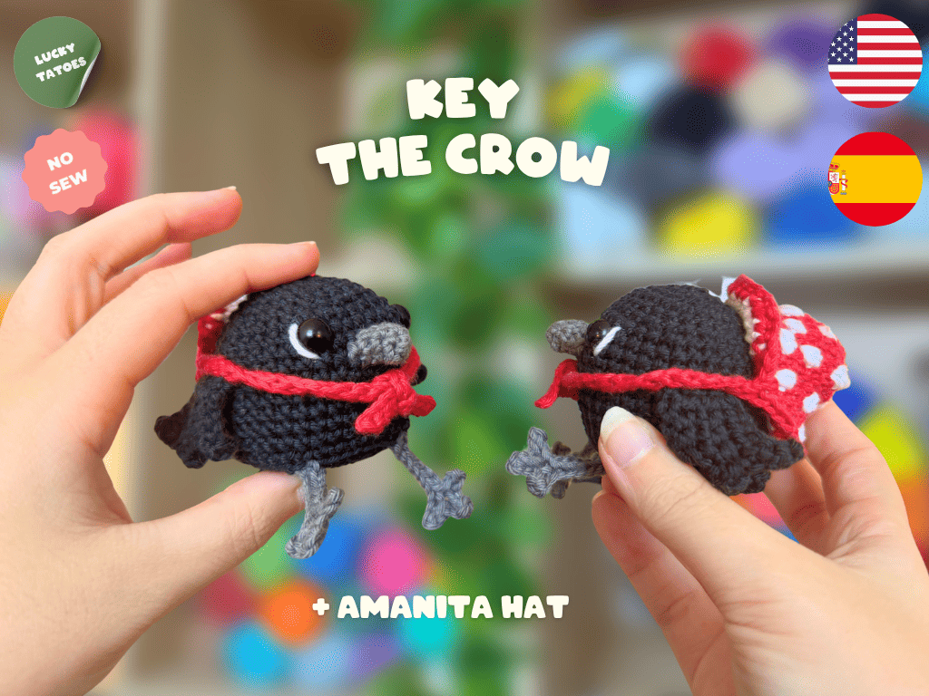 Two small crocheted crow characters wearing purple witch hats with yellow bands are held in human hands against a colorful blurred background. Text reads 'KEY THE CROW' and '+ WITCH HAT', with 'LUCKY TATTOO' and 'NO SEW' badges plus US and Spain flags.