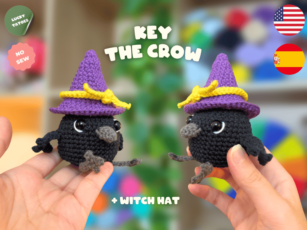 Two small crocheted crow characters wearing purple witch hats with yellow bands are held in human hands against a colorful blurred background. Text reads 'KEY THE CROW' and '+ WITCH HAT', with 'LUCKY TATTOO' and 'NO SEW' badges plus US and Spain flags.