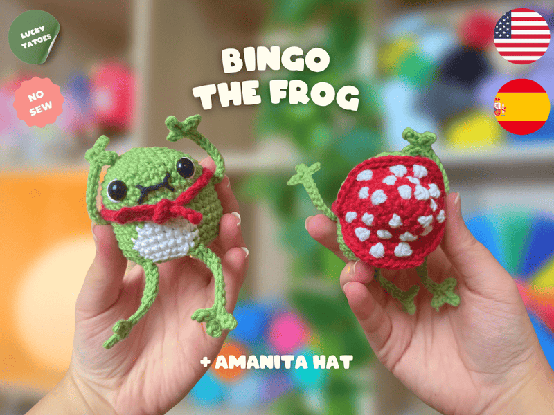 Two hands holding crocheted frog toys in front of a blurred colorful background. The left frog is green with a white belly and red hat, and the right frog has a red with white spots hat.