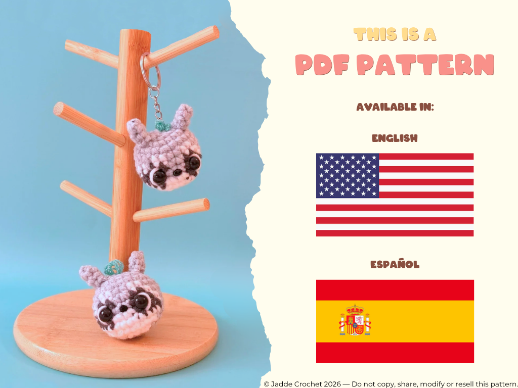 Two small crocheted raccoons on a wooden stand with text about a PDF pattern available in English and Spanish.